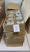 Cardboard box containing multiple compartments, each holding several individually bubble-wrapped ceramic cherub candles.