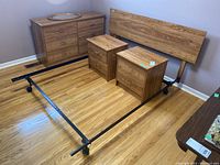 Wide view of the bedroom set showing the bed frame with wood veneer headboard, 6 drawer dresser with mirror on top, and two matching side tables.