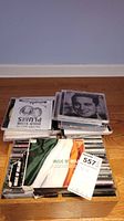 Top view of box of CDs showing a variety of jewel cases and visible titles including Irish music compilation and Elvis Presley CD
