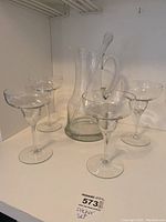 Full set of pitcher and four glasses arranged on shelf, showcasing all six pieces together.