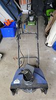 Front angled view of an 18 inch electric SnowJoe snowblower showing the handle, chute, and auger housing.