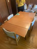 Table fully set up with both drop leaves raised and four chairs arranged around it