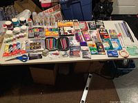 Table overview of art supplies (paints, mediums, markers, pencils, tools)