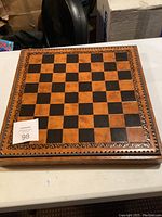 Closed board showing chess side with carved wood border and veneer squares