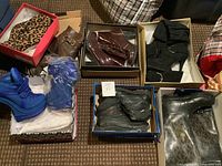 Wide shot of all boots in open boxes on floor for overview of lot