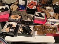 Overview of eight pairs of shoes in individual boxes on table