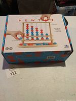 Closed box showing the Newton ball game brand and packaging design.
