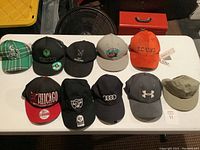 Full lot with 11 hats displayed on table, various brands and styles visible