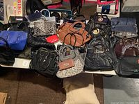 Photo showing a large variety of purses including quilted black, leopard print clutch, blue handbag, brown satchel, red clutch, and others grouped together on a surface.