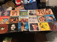 Photo showing multiple vinyl record covers laid flat including titles from Diana Ross, Linda Ronstadt, and others.