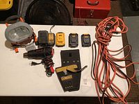 Overview of Snap-on heat gun, work light, DeWalt chargers, holster and extension cord on table