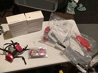 Full view of the items laid out on a white table: respirator mask, boxes of face masks, packaged face shields, and replacement cartridges.