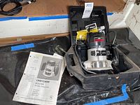 Craftsman router in carry case with owner's manual and packages of router bits visible