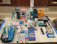Full assortment overview of unopened personal care products including body wash, razors, toothbrushes, toothpaste, Q-tips, band-aids, and more.