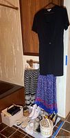 Overview of dresses, skirts, shoes, purses and storage box.