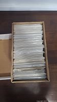 Photo of a box filled with individually sleeved comics, stacked vertically and tightly packed.