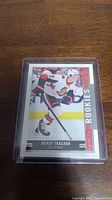Front side of Brady Tkachuk rookie hockey card in plastic case showing player image and Glossy Rookies label.