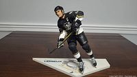 Front and side view of the McFarlane 12 inch Mario Lemieux figure in Pittsburgh Penguins uniform on base.
