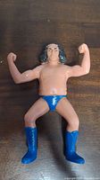 Front view of the vintage LJN Andre The Giant wrestling action figure with arms flexed and blue boots and trunks.