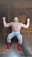 Front view of the LJN Big John Stud wrestling figure showing paint wear on pants and arms flexed.