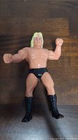 Front view of the wrestling action figure showing blonde hair, black trunks and boots.