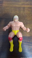 Top view of LJN Hulk Hogan Thumb Wrestler showing muscular torso, yellow trunks, red knee pads, and yellow boots.