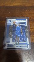Front side of Zion Williamson rookie basketball card featuring him in Duke uniform during play, with School Colors label and Panini Contenders Collegiate logo.