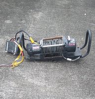 Full view of ZX12000 12,000 lb electric winch laying on concrete surface, with steel cable wound on drum and wiring harness attached.