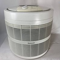 Front view of white Honeywell 50250 air purifier showing circular design with vents and brand label.