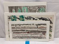 Three Chinese ink paintings stacked showing landscape scenes with brush strokes in earthy tones and green highlights.