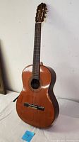 Full view of the vintage Degas classical guitar showing natural wood finish, nylon strings, and overall shape.