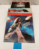 Photo of vinyl records with visible title Ted Nugent - Weekend Warriors, The Doors album, and Sandinista! by The Clash at the back