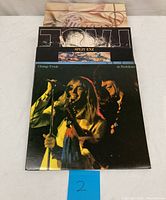 Stack of vinyl record album covers including Cheap Trick at Budokan, Split Enz Time and Tide