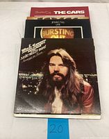 Stack of 15 classic rock and pop vinyl records with covers showing including Bob Seger, Jethro Tull, and The Cars.