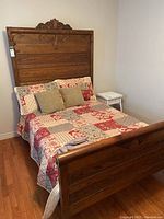 Wide shot showing assembled bed frame with mattress, quilt and pillows