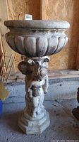Front and side view showing the planter's basin and cherub angel base with octagonal pedestal.