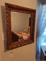 Mirror mounted on the wall showing the entire rectangular frame and partial room reflection.