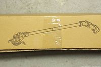 Cardboard box with printed illustration of a garden trimmer.