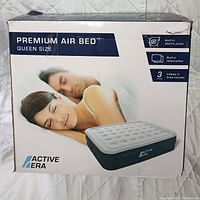 Front of box showing Active Era Premium Air Bed Queen Size with built-in electric pump, raised pillow, and three-minute inflation feature.