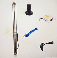 Full pump assembly with accessories: control box, power cables, and hose adapter fitting spread out on white background
