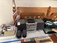 Sony stereo system with two large speakers, two smaller speakers in front, and electronic accessories on left side.