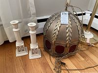 Photo showing two Lenox porcelain candlestick holders beside a large metal hanging lamp with chains.