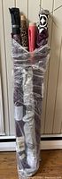 Four rolls of fabric standing in a plastic bag, showing tops and length of fabric rolls.