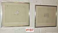 Two framed coloured pencil sketches on beige paper with visible tape marks, hung on a white brick wall, side by side