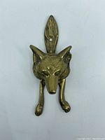 Top view of the brass fox door knocker showing detailed fox head and front legs.