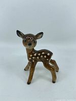 Front and side view of the brown and white spotted Bambi figurine standing upright on all four legs.