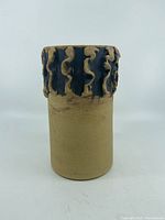 Front view of handmade 1970's Jersey Pottery clay vase showing plain cylindrical body with textured dark decorative rim top.