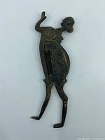 Image of antique metal betel nut cutter shaped like a standing lady with intricate body decorations and patina.