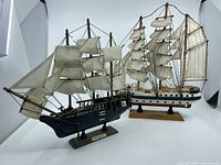 Two wood model sailboats A. Von Humboldt (front) and HMS Bounty (back) shown side by side with stands and sails visible.