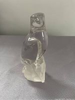 Front view of clear crystal glass eagle figurine showing detailed head and body perched on faceted crystal base.